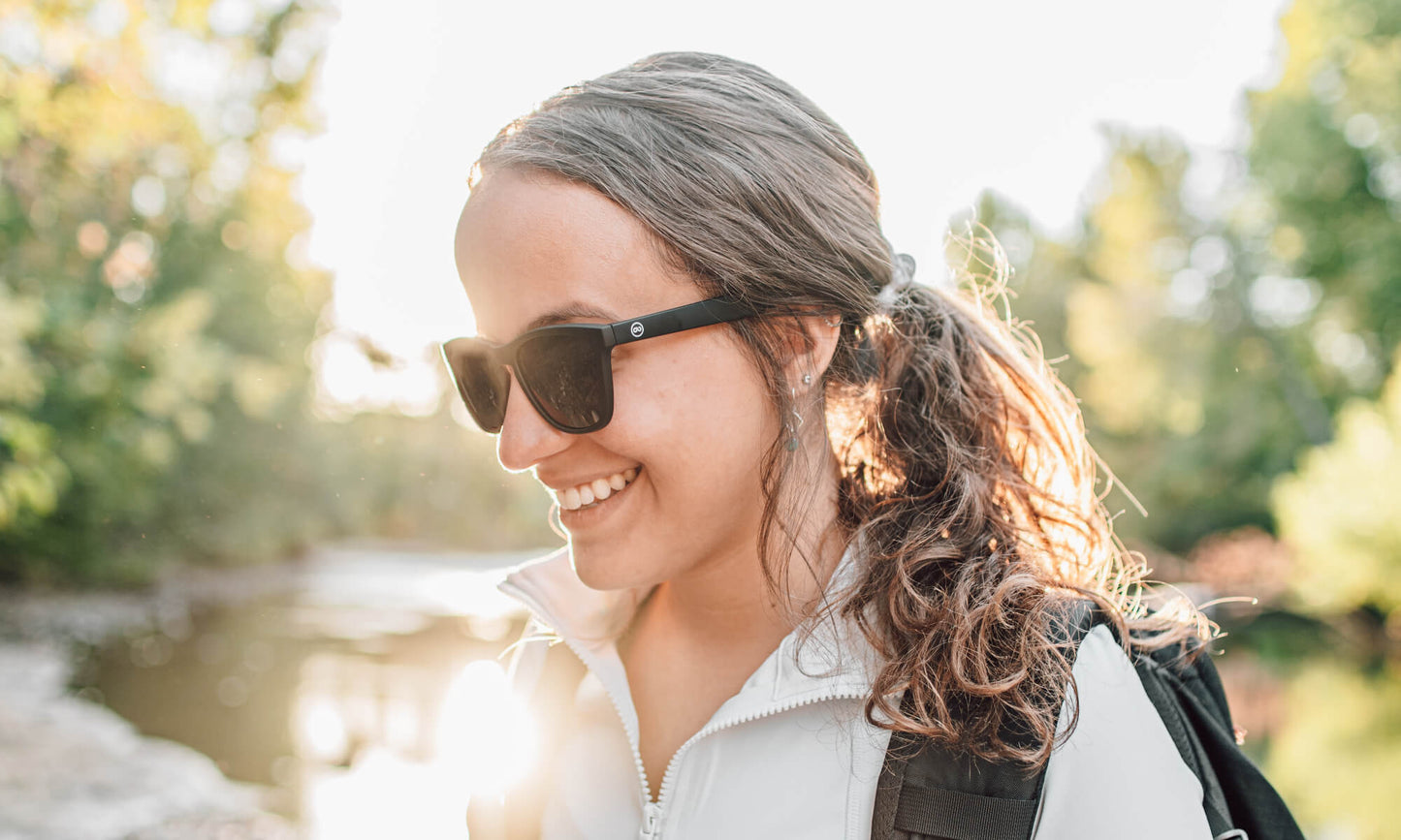 girl in black sunglasses by the river
