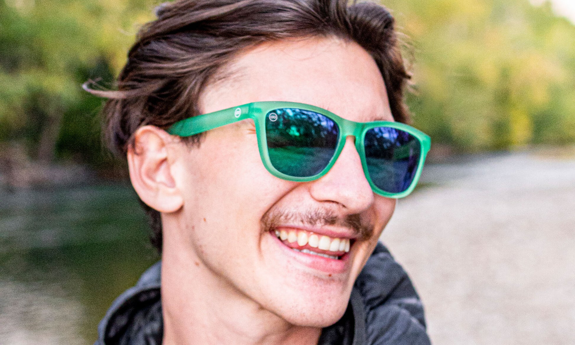 closeup of a man wearing green and blue sunglasses